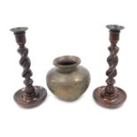 A pair of oak candlesticks, with spirally turned columns, 26cm high, and an Indian brass vase. (3)
