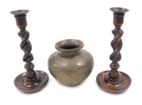 A pair of oak candlesticks, with spirally turned columns, 26cm high, and an Indian brass vase. (3)
