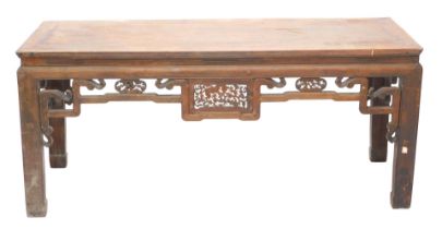 A Chinese red stained low altar table, with a pierced carved frieze on shaped legs, 80cm high, 185cm