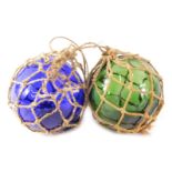Two coloured glass fishing floats, with string binding.