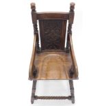 A carved oak child's highchair in 18thC style, with a carved back, shaped arms and solid seat, on sp