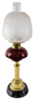 A Victorian style oil lamp, with frosted shade and ruby tinted cut glass reservoir, on a brass base,