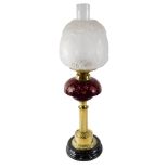 A Victorian style oil lamp, with frosted shade and ruby tinted cut glass reservoir, on a brass base,