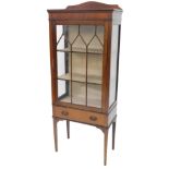 An early 20thC mahogany display cabinet, with a raised back, single glazed door and a drawer, on squ