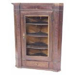 A late George III oak and mahogany hanging corner cabinet, with a moulded cornice above a panelled d