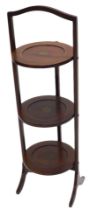 An Edwardian mahogany and simulated marquetry three tier folding cake stand, 86cm high.