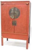 A Chinese red painted cabinet, with metal mounts, 182cm high, 110cm wide.