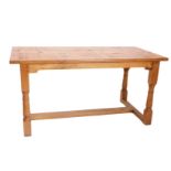 A light oak refectory table, the planked top with cleted ends, on part turned supports with flat H s