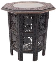 An Indian hardwood folding occasional table, the octagonal top carved with leaves and flowers, etc.,