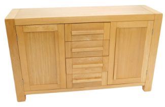 A light oak sideboard, with arrangement of four drawers and two doors, on stiles, 142cm wide.