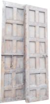 A large pair of Continental pine panelled doors, each with some metal fittings, 270cm x 69cm.