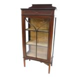 An Edwardian mahogany and boxwood strung display cabinet, with a raised back above a glazed door, on