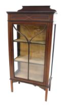 An Edwardian mahogany and boxwood strung display cabinet, with a raised back above a glazed door, on