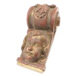 A red and gilt painted carved wooden support or corbel, 51cm high.