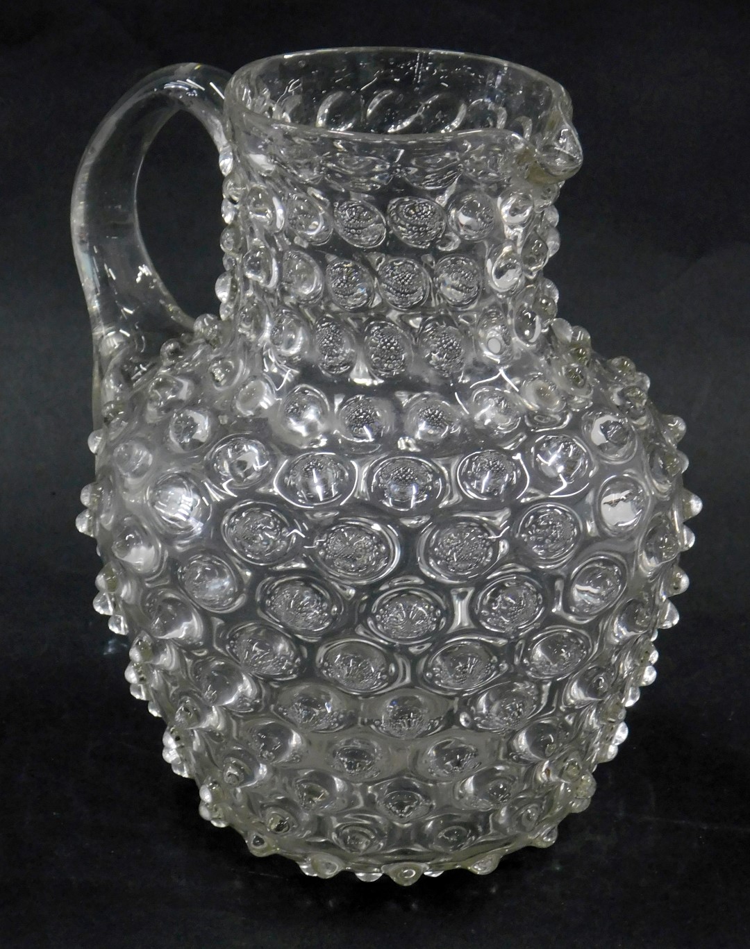 A Victorian glass jug, with raised decoration, 18cm high.