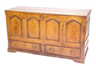 A late 18th/early 19thC oak and mahogany mule chest, the planked top with a moulded edge enclosing a