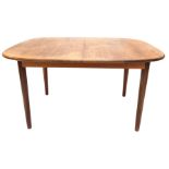 An extending teak dining table, with rectangular top with rounded corners, on turned tapering legs,