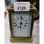 A 20thC brass carriage clock, with an overpainted white enamel Roman numeric dial, on square base, 1