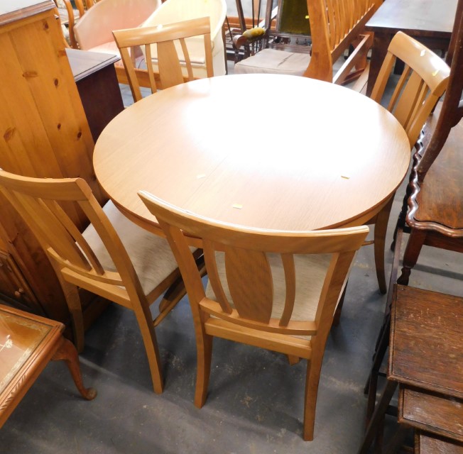 A beech effect extending circular kitchen table, and four chairs, 77cm high, 100cm diameter, extende