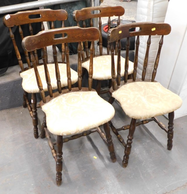 A set of four stained beech pub chairs, each with gold leaf upholstery. The upholstery in this lot