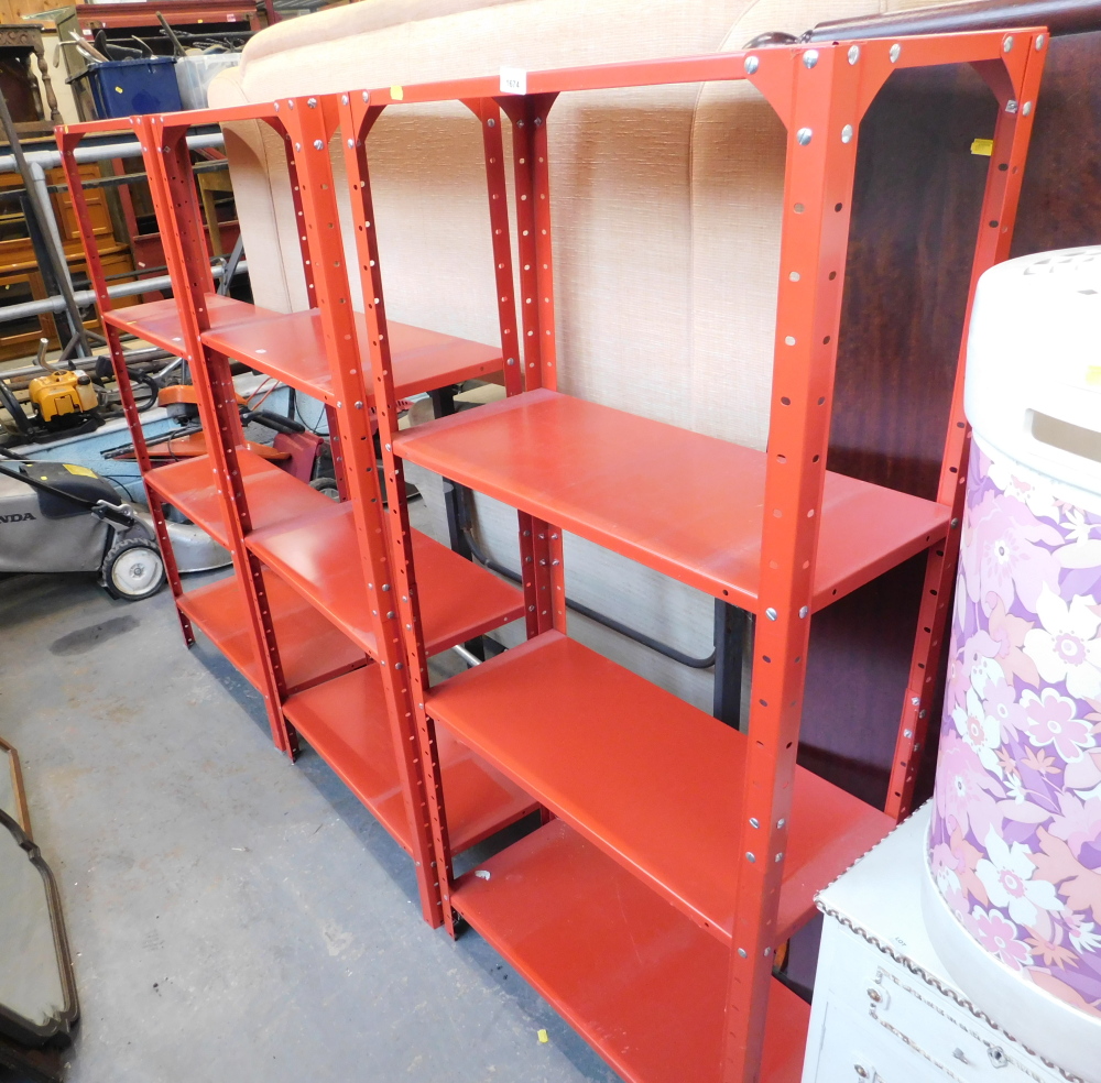 Three red metal shelving units.