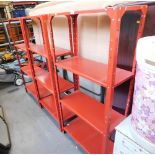 Three red metal shelving units.