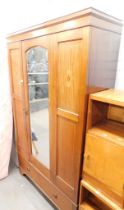 An Edwardian mahogany and inlaid wardrobe, the top with a moulded cornice above a mirrored door, wit