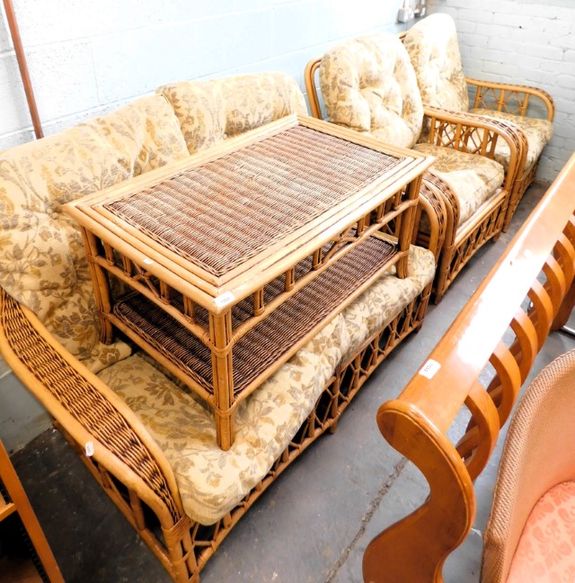 A cane conservatory suite, comprising two seater sofa, two arm chairs, and a coffee table. The uphol