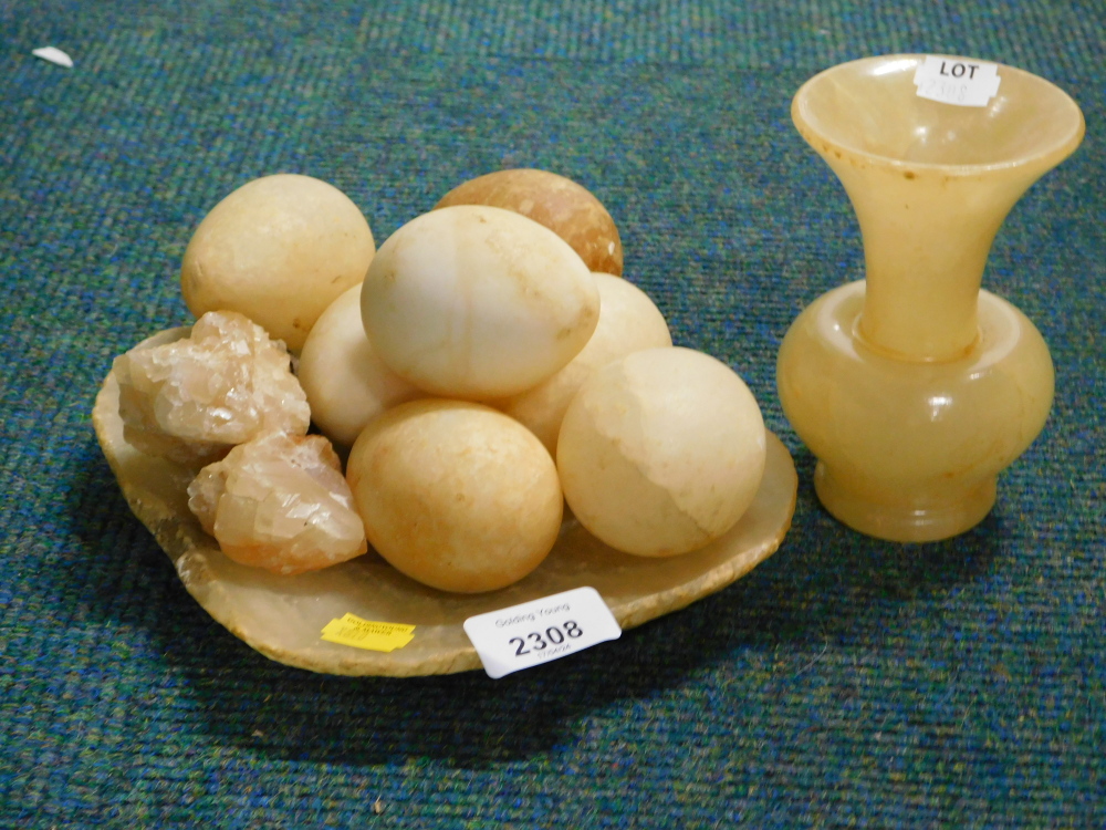 A soapstone dish, various eggs and a vase.