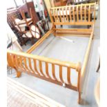 A walnut double bed frame, for a sleigh bed with raised and arched ends, with slats.