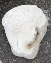 A reconstituted stone lady's face wall mounted plaque, in the Art Nouveau style, 31cm high.