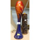 An Art Glass stem vase, on an orange and blue mottled ground, 38cm high, and a candle, 27cm high. (2