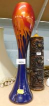 An Art Glass stem vase, on an orange and blue mottled ground, 38cm high, and a candle, 27cm high. (2