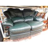 A green leatherette two seater sofa.