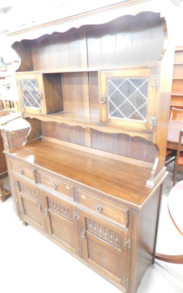 A Jaycee oak dresser, the carved and railed back, with two glazed doors above arrangement of three d