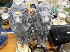 Two composite silver finish lions.