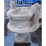 A reconstituted stone two handled urn planter, in the Neoclassical style, on a circular foot, 50cm h