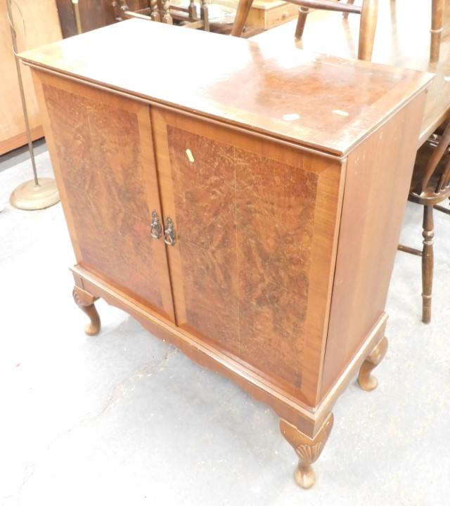 A reproduction walnut television cabinet, on cabriole legs.