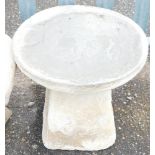 A reconstituted stone saddle stone, 36cm high.