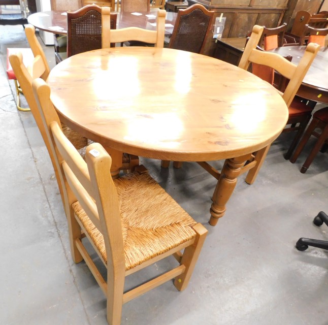 A pine circular kitchen table and set of four chairs.