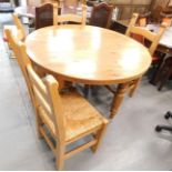 A pine circular kitchen table and set of four chairs.