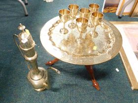 An Indian brass coffee set, comprising coffee pot, six goblets, and a serving tray on wooden base.