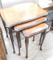 A reproduction mahogany nest of tables.