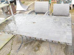 A slate top rectangular garden table and six rattan chairs.