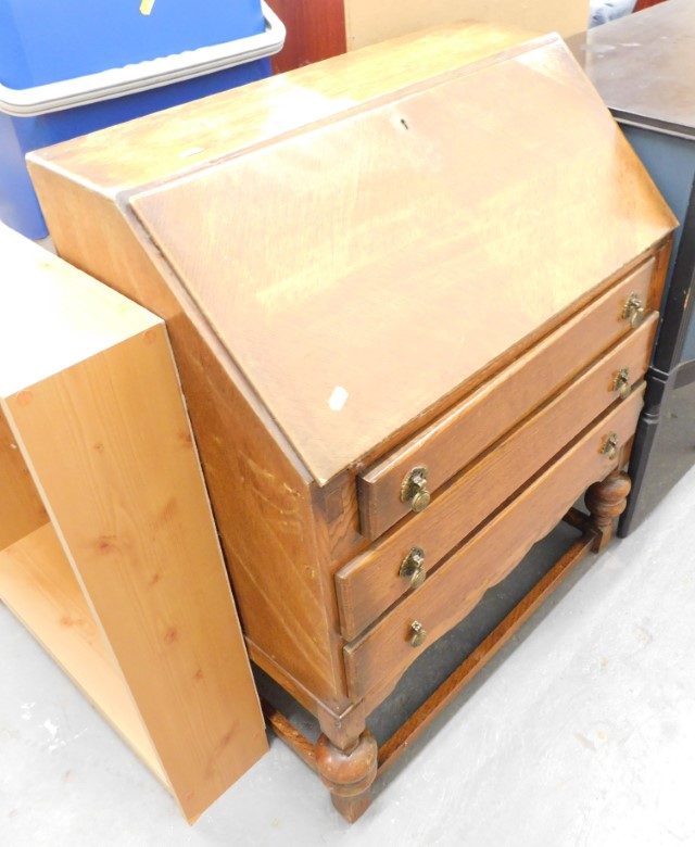 A 1950s oak bureau, the fall flap opening to reveal a fitted interior above three drawers, on bulbou