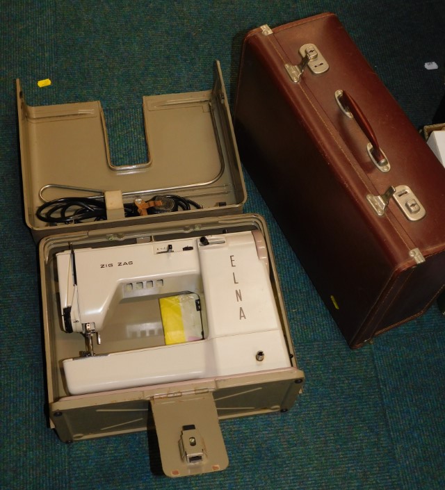 A sewing machine and a brown leatherette case. (2)