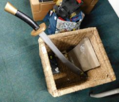 A wicker storage basket and contents, to include phone case and a wooden play sword. (1 box)