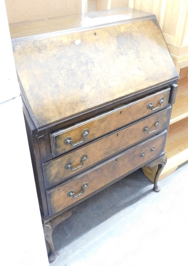 An early 20thC burr walnut bureau, the fall flap opening to reveal a fitted interior above arrangeme