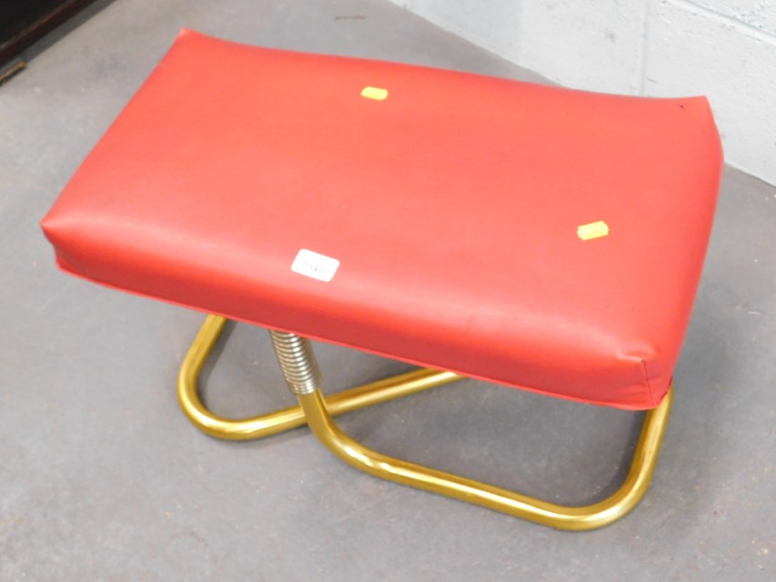 A retro stool, on red leatherette top, on gold finish base. The upholstery in this lot does not comp