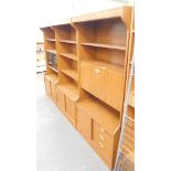 A retro style teak wall unit, in three sections to include cupboard top, cocktail cabinet and cupboa